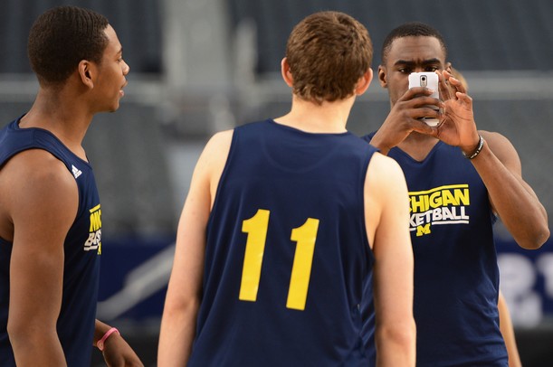 Michigan junior Tim Hardaway Jr. takes a photo with his cellphone as the team checks out the court set up in the center of Cowboys Stadium in Arlington, Texas on Thursday, March 28, 2013. Melanie Maxwell I AnnArbor.com